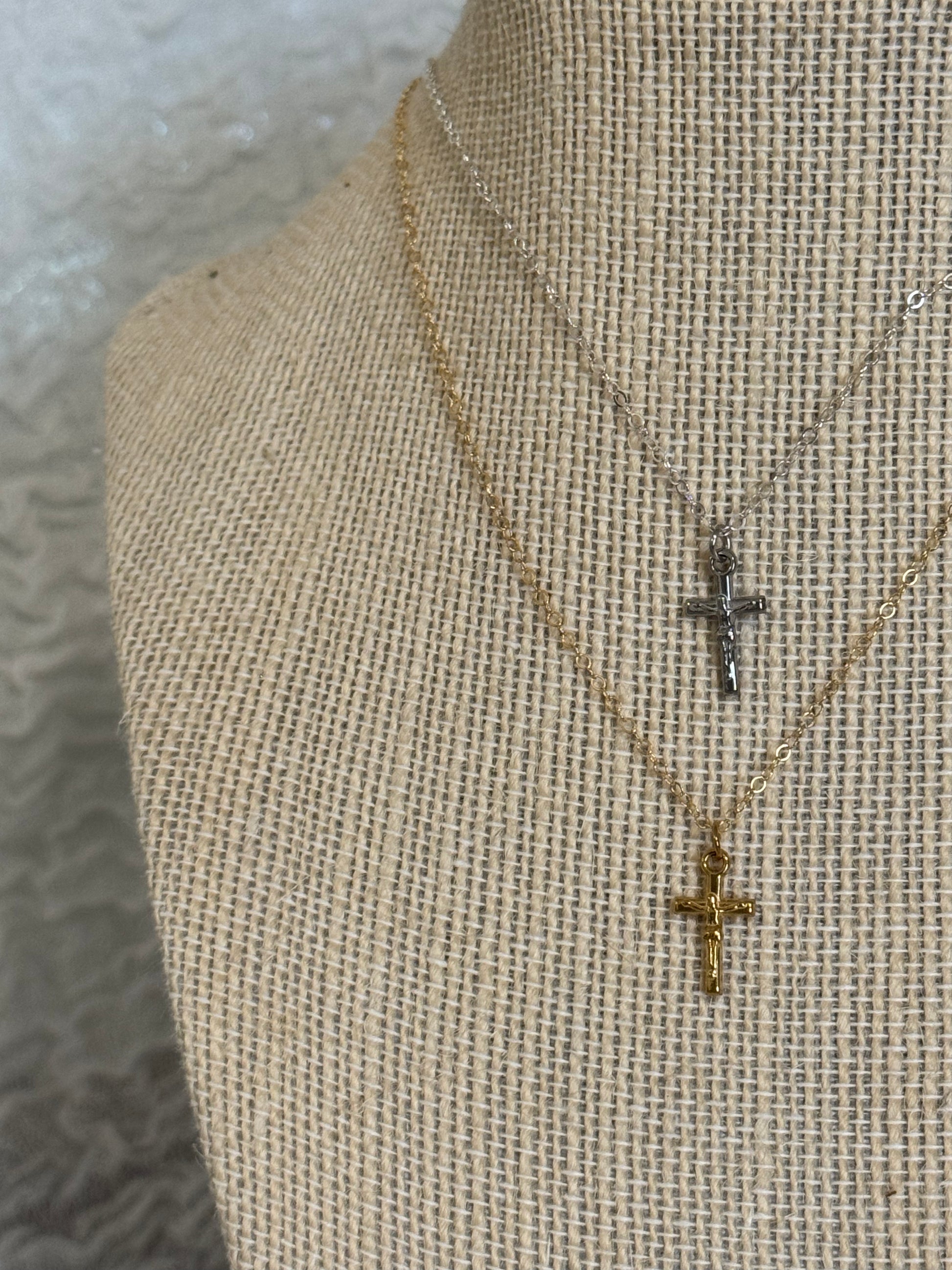 14k gold filled and sterling silver dainty crucifix necklaces shown together